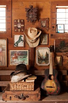 there is a guitar, cowboy hat and other items on the table in this room