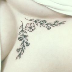 a woman's stomach with flowers and leaves tattooed on the side of her breast