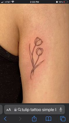 a small flower tattoo on the back of a woman's left arm and shoulder