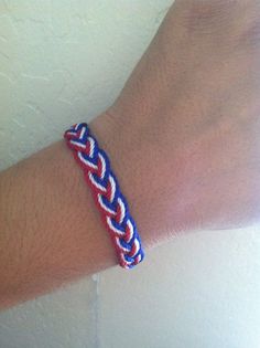 a person wearing a red, white and blue bracelet