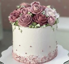 there is a white cake with pink roses on it