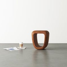 a small wooden object sitting on top of a table next to a cup of coffee