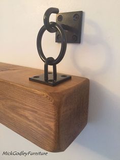 a wooden shelf with an iron ring on it