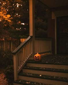 a pumpkin sitting on the steps of a house