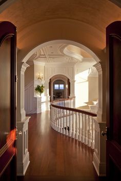 an archway leading to a foyer with wood flooring and white railings on both sides