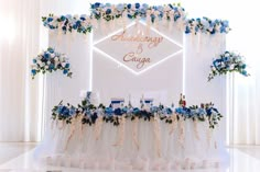 a table with flowers and candles on it in front of a white backdrop that says wedding & engagement