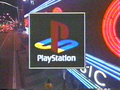 the playstation logo is displayed on a television screen in front of neon signs at night