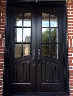 a black double door with two sidelights on a brick building