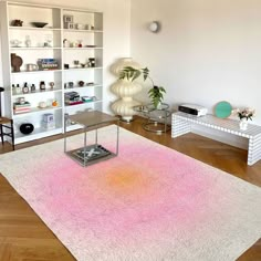 a living room filled with furniture and a pink rug