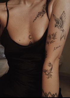 a woman with tattoos on her arm and chest