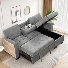 a grey couch with a pull out bed underneath it