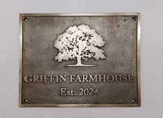 a metal sign that says griffin farmhouse est 2094 with a tree on it