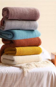 a stack of towels sitting on top of a bed