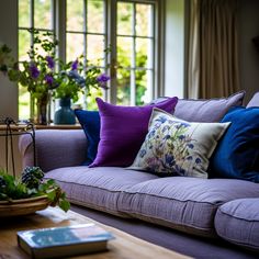 a living room filled with purple couches and pillows