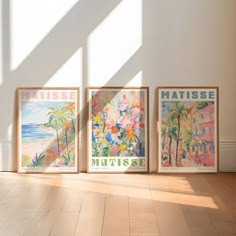 three framed art prints on the wall in a room with hard wood floors and white walls