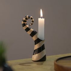 a black and white striped candle holder on a table