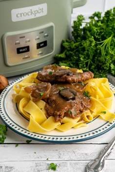 pasta with mushrooms and sauce on a plate next to an instant pressure cooker in the background