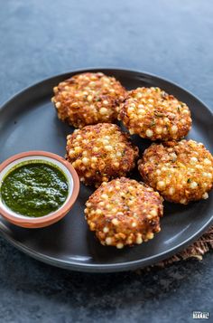 some food on a black plate with green sauce