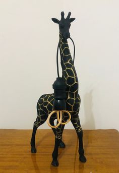 a giraffe standing on top of a wooden table next to a bottle opener