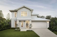 a white two story house with lots of windows and grass in front of the house