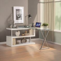 a desk with a computer on top of it in a living room next to a window