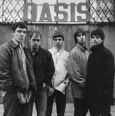 a group of young men standing next to each other in front of a sign that says oasis