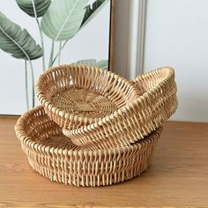 two wicker baskets sitting on top of a wooden table next to a framed photo