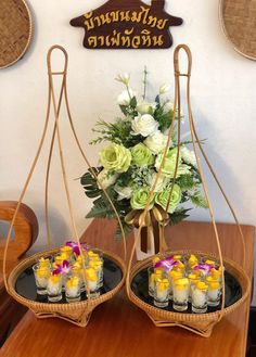 two trays filled with candles and flowers on top of a wooden table