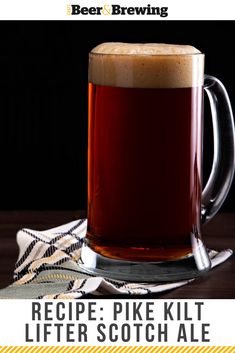 a mug of beer sitting on top of a table next to a napkin and spoon