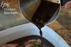 someone pouring sauce into a white bowl filled with meat