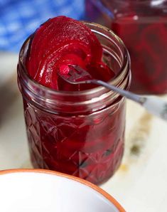 two jars filled with red liquid sitting on top of a table