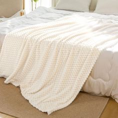 a large white blanket on top of a bed