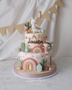 a three tiered cake decorated with animals and rainbows