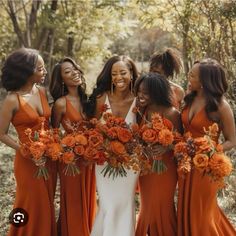 a group of women standing next to each other holding bouquets in front of them