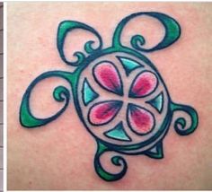 the tattoo on the back of a woman's shoulder is decorated with pink and green flowers