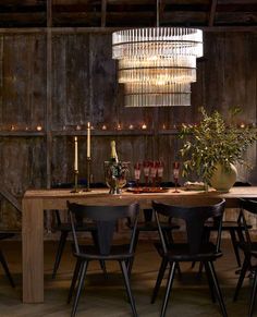 a dining room table with chairs and a chandelier hanging from it's ceiling