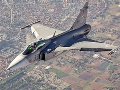 a fighter jet flying through the air over a city