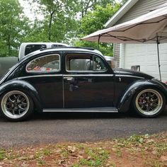 an old beetle parked in front of a garage