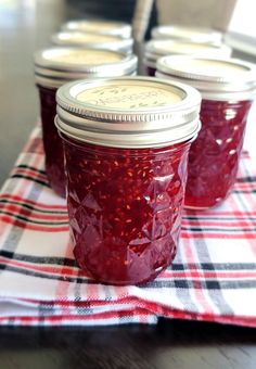 four jars of jam sitting on top of a table