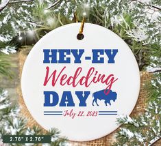 a white ornament that says hey - ey wedding day with an image of a bison on it