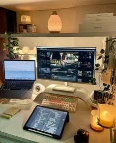 a laptop computer sitting on top of a desk next to a desktop computer monitor and keyboard