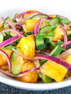 a white bowl filled with lots of veggies and onions on top of a table