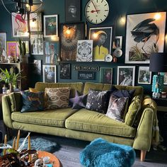 a living room filled with green couches and pictures on the wall next to a coffee table