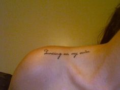 the back of a woman's shoulder with an inscription on it