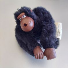 a stuffed gorilla is laying down on the floor with its eyes open and tongue out