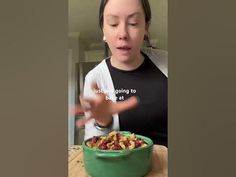 a woman is holding her hands out in front of a bowl of cereal