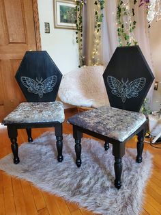 two black and white chairs sitting on top of a wooden floor