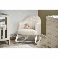 a baby's rocking chair with a stuffed animal on it in a nursery room