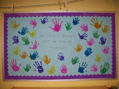 a bulletin board with handprints on it that says we come as strangers and we have as friends