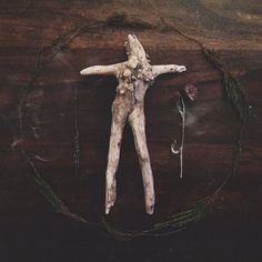 a dead person laying on top of a wooden table next to a string and flower